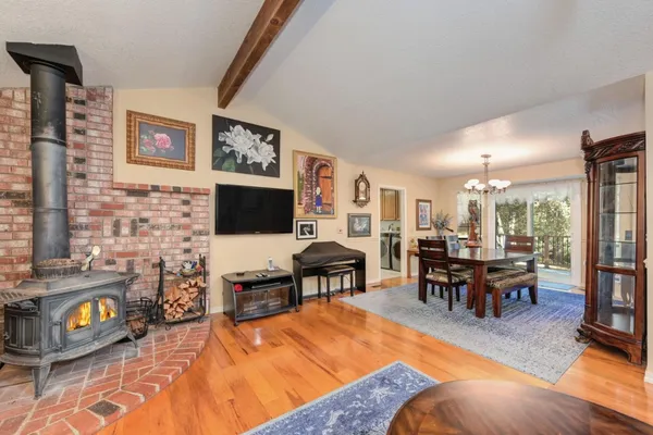 a dining room with wooden floor a chandelier a wooden table and chairs
