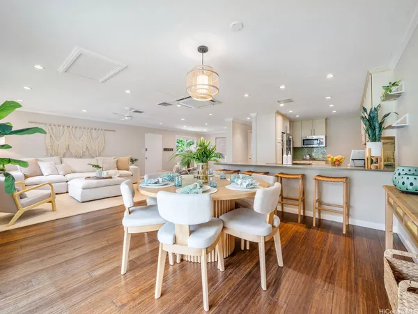 a view of a dining room with furniture wooden floor and a kitchen view