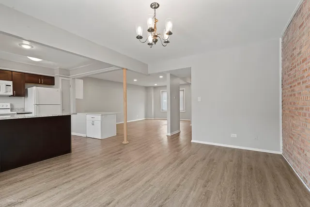 a view of a kitchen with wooden floor and a kitchen space
