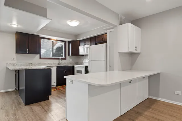a kitchen with a sink a refrigerator and a stove top oven