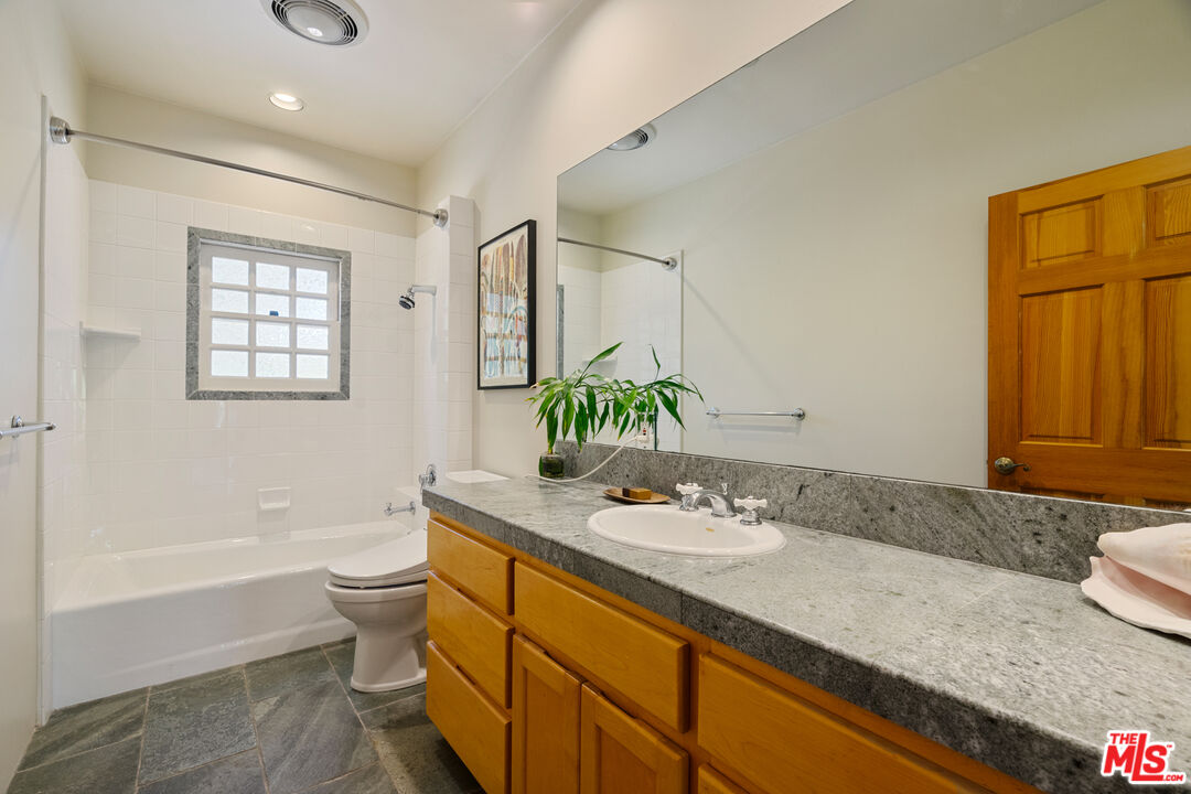 20912 Fontaine Road Topanga, CA 90290 - Photo 28 of 52 a bathroom with a granite countertop sink a toilet and shower