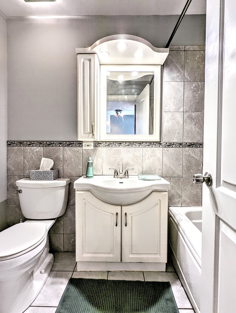 9418 Dee Road, Unit 203C Des Plaines, IL 60016 - Photo 13 of 24 a bathroom with a sink and a mirror