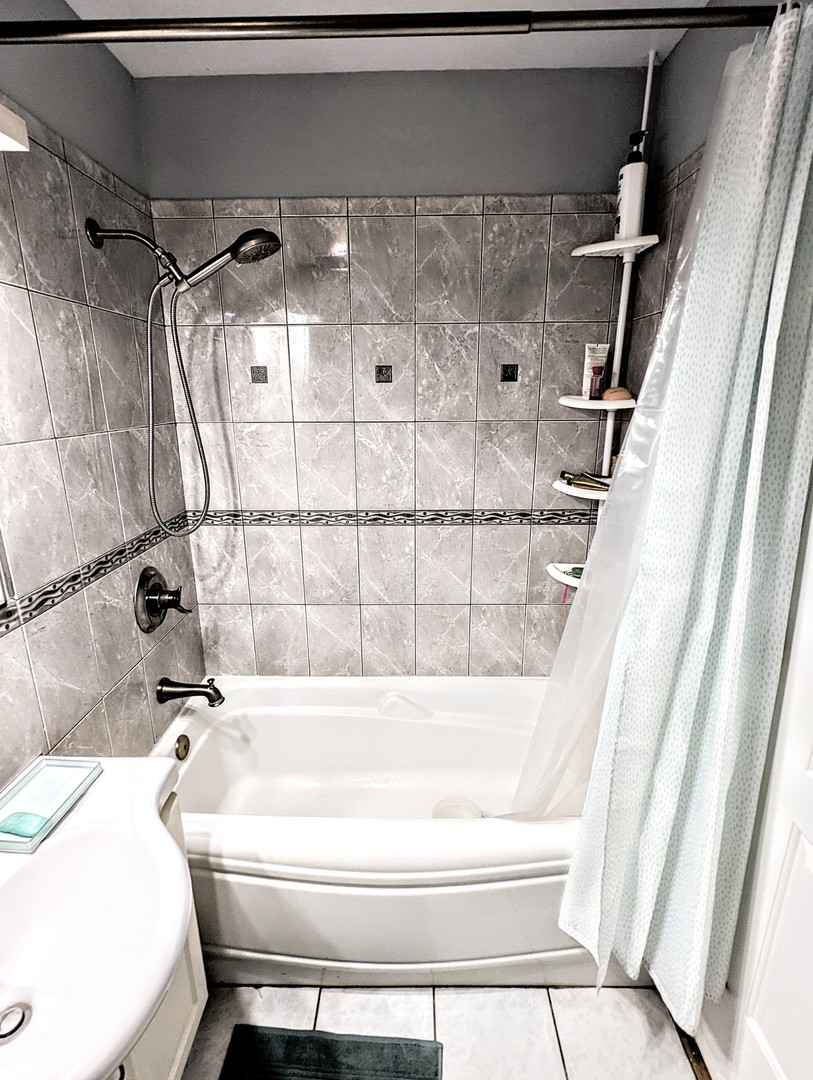 9418 Dee Road, Unit 203C Des Plaines, IL 60016 - Photo 14 of 24 a bathroom with a bathtub and shower