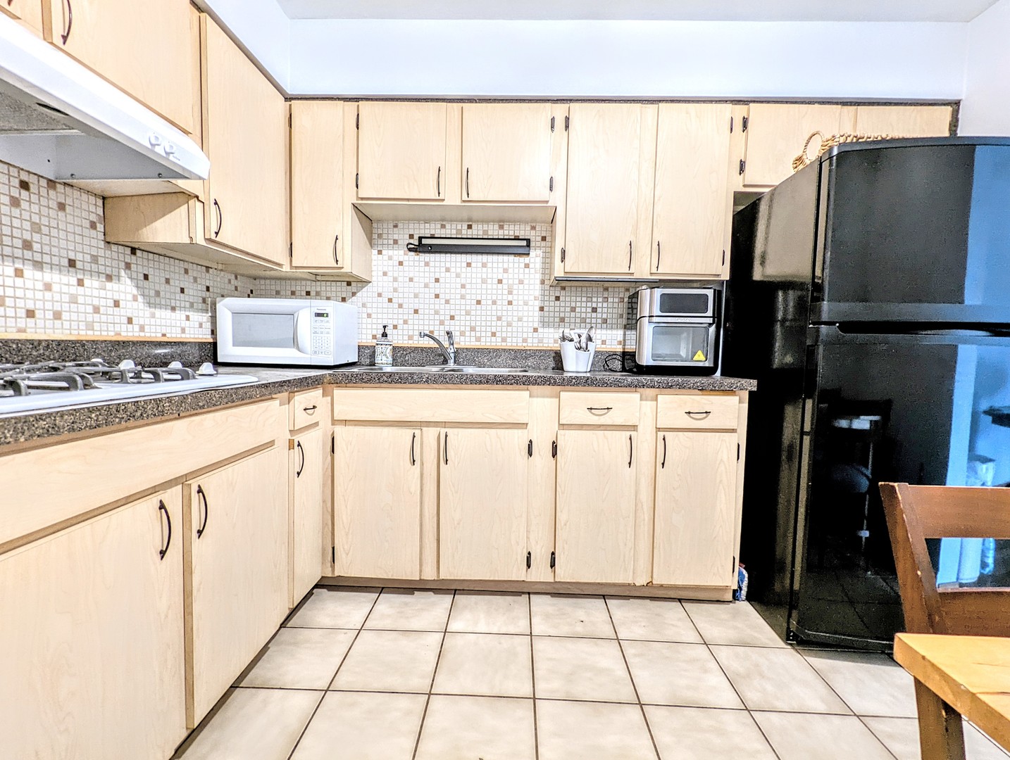 9418 Dee Road, Unit 203C Des Plaines, IL 60016 - Photo 3 of 24 a kitchen with granite countertop a sink a stove and cabinets