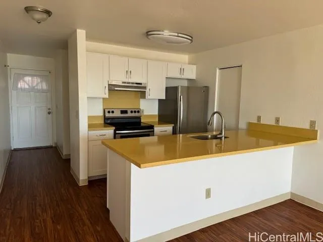 a kitchen with stainless steel appliances a sink a stove a refrigerator and cabinets