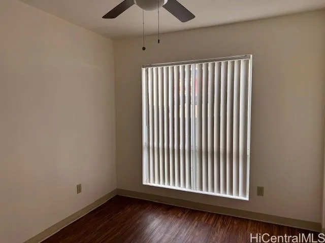 an empty room with wooden floor chandelier fan