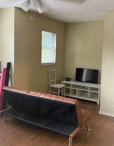 a backyard with wooden fence and a large tree