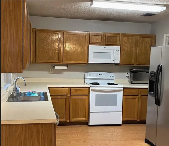 a kitchen with stainless steel appliances a stove a sink and a refrigerator