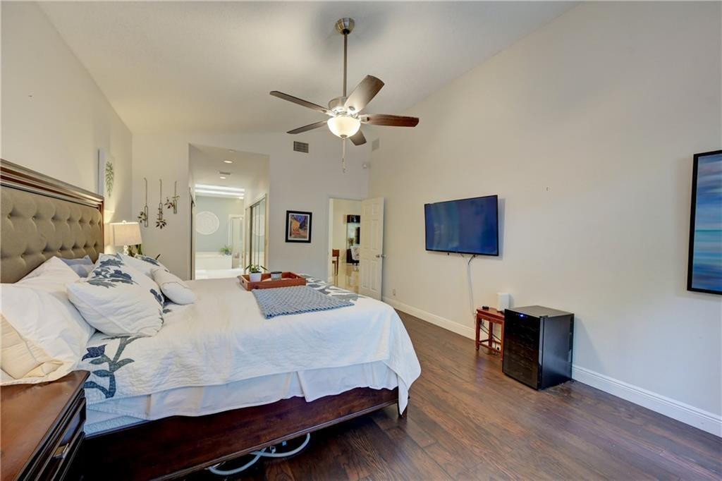 8171 Hampton Wood Drive Boca Raton, FL 33433 - Photo 16 of 56 a bedroom with a bed and a chandelier