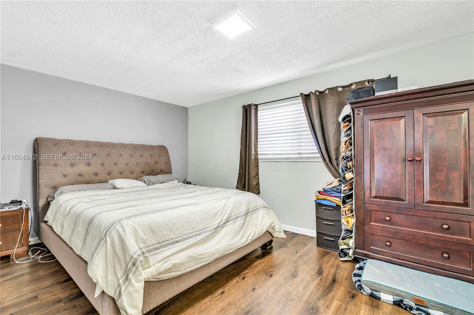 875 East 29th Street Hialeah, FL 33013 - Photo 9 of 38 a bedroom with a bed a dresser and wooden floor