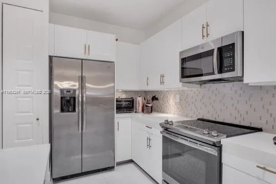 a kitchen with stainless steel appliances a refrigerator stove and microwave