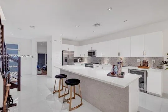 a kitchen with stainless steel appliances a refrigerator and cabinets