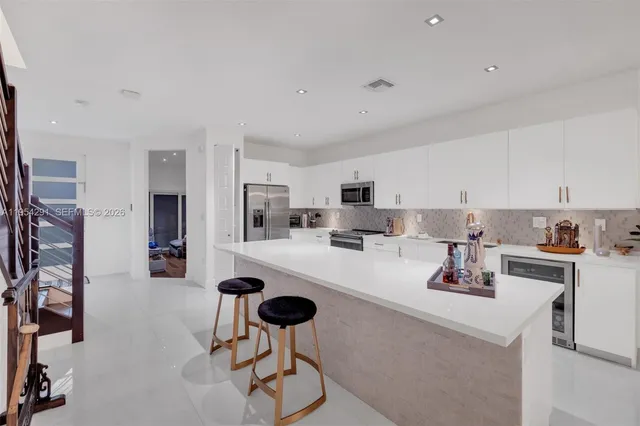 a kitchen with cabinets and chairs