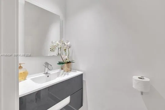 a bathroom with a sink vanity and a mirror