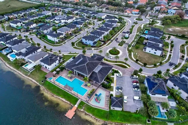 an aerial view of residential houses with outdoor space and parking