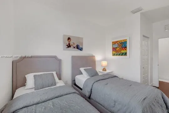 a bedroom with a bed and painting on the wall