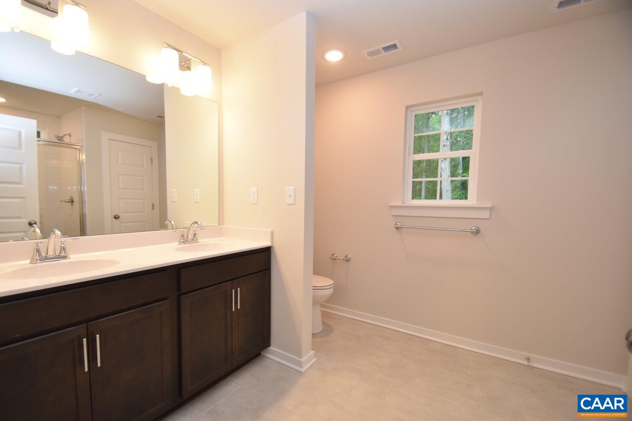 88 Martin Village Road, Unit MV 16D Louisa, VA 23093 - Photo 25 of 37 a bathroom with a double vanity sink a toilet and a mirror