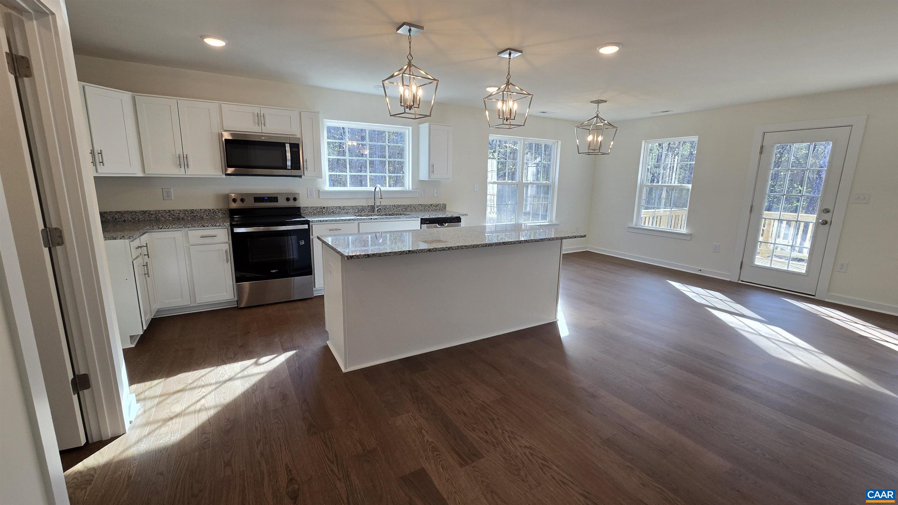 88 Martin Village Road, Unit MV 16D Louisa, VA 23093 - Photo 7 of 41 a kitchen with stainless steel appliances granite countertop a refrigerator a sink dishwasher a stove and white countertops with wooden floor