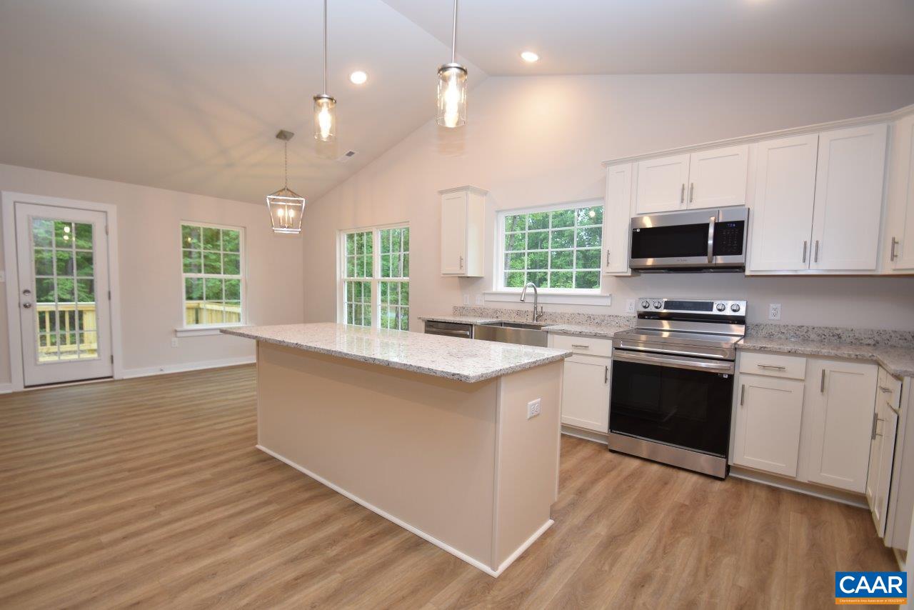 88 Martin Village Road, Unit MV 16D Louisa, VA 23093 - Photo 10 of 37 a kitchen with granite countertop a stove top oven a sink dishwasher a dining table and chairs with wooden floor