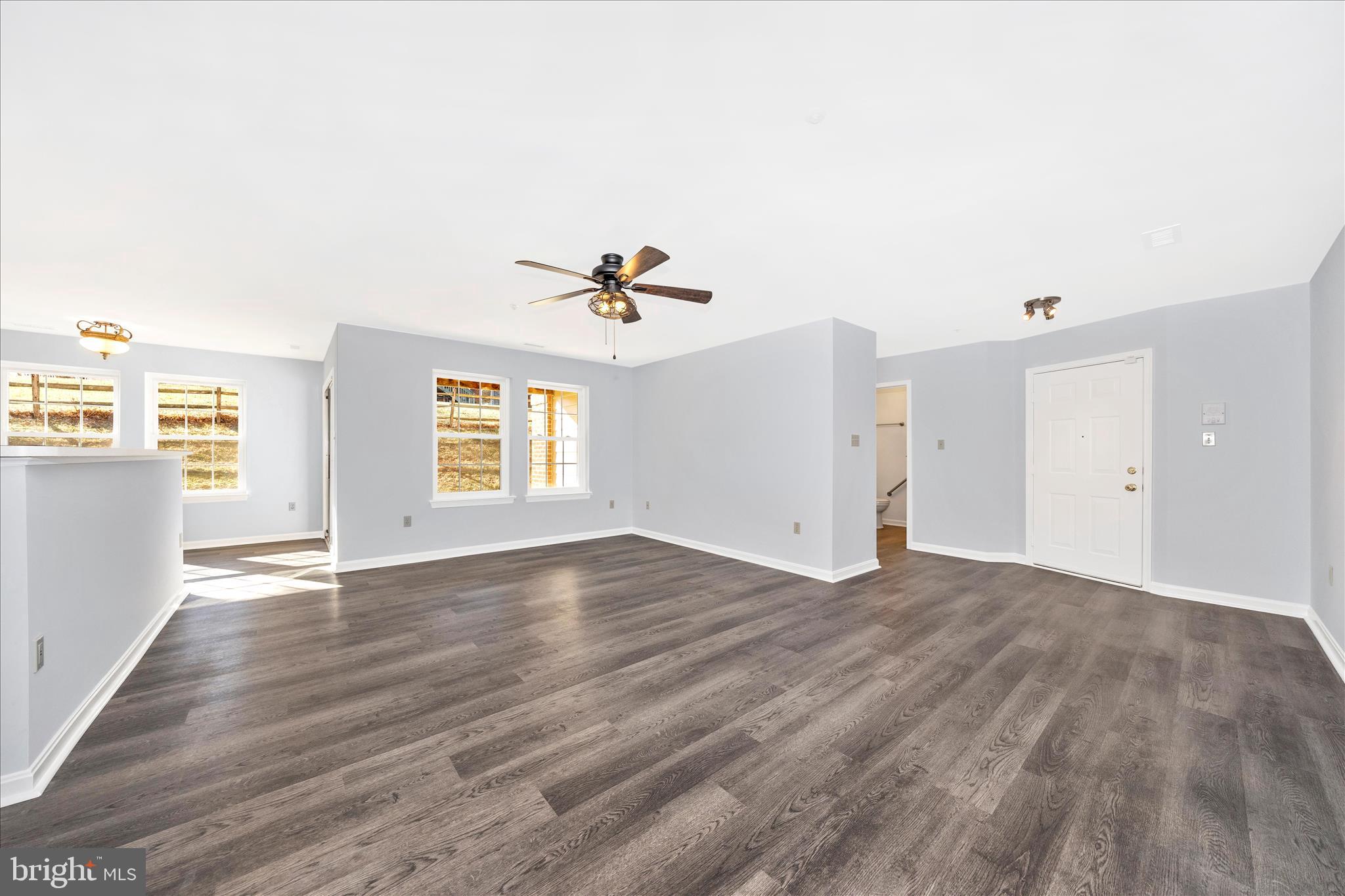 2402 Dominion Drive, Unit 1B Frederick, MD 21702 - Photo 6 of 66 a view of an empty room with wooden floor and a window