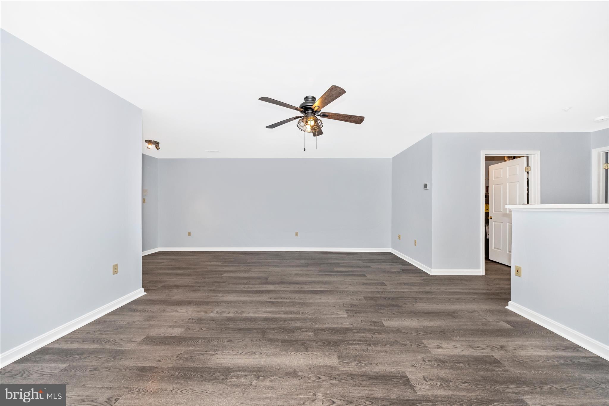 2402 Dominion Drive, Unit 1B Frederick, MD 21702 - Photo 8 of 66 an empty room with wooden floor and a ceiling fan