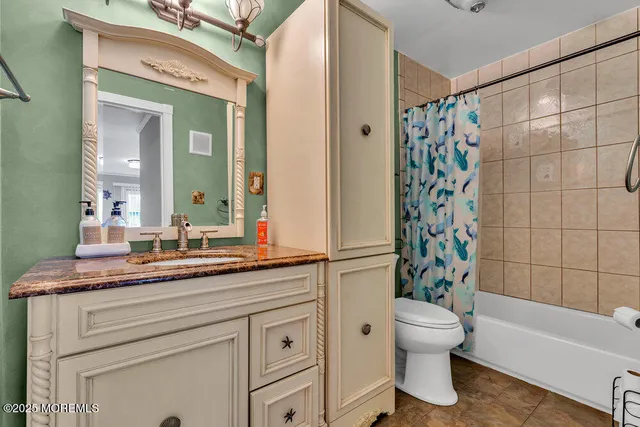 a bathroom with a granite countertop sink toilet a mirror a bathtub and shower
