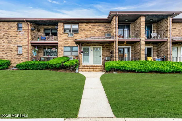 a front view of a brick house with a yard