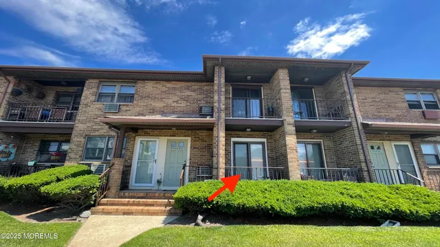 a view of a house with brick walls and a yard with plants