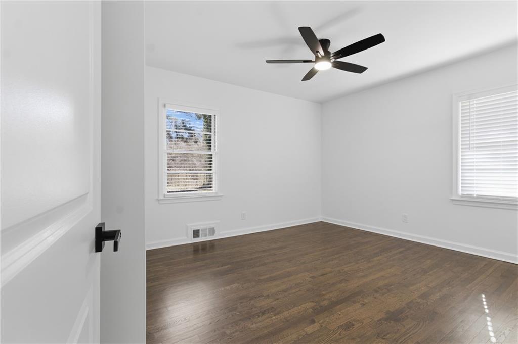 1410 Willis Mill Road Southwest Atlanta, GA 30311 - Photo 16 of 33 an empty room with wooden floor and windows