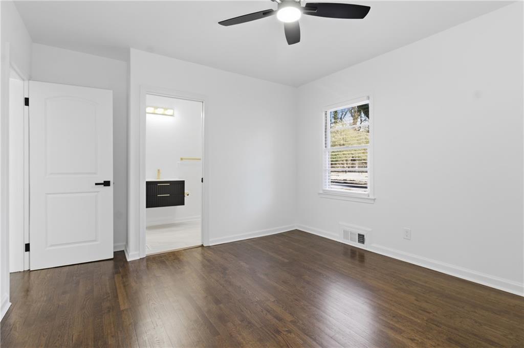 1410 Willis Mill Road Southwest Atlanta, GA 30311 - Photo 17 of 33 an empty room with wooden floor cabinet and windows