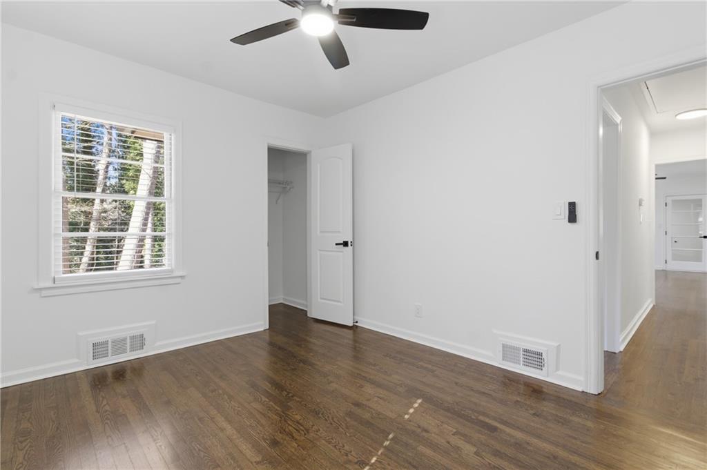 1410 Willis Mill Road Southwest Atlanta, GA 30311 - Photo 22 of 33 an empty room with wooden floor chandelier fan and windows