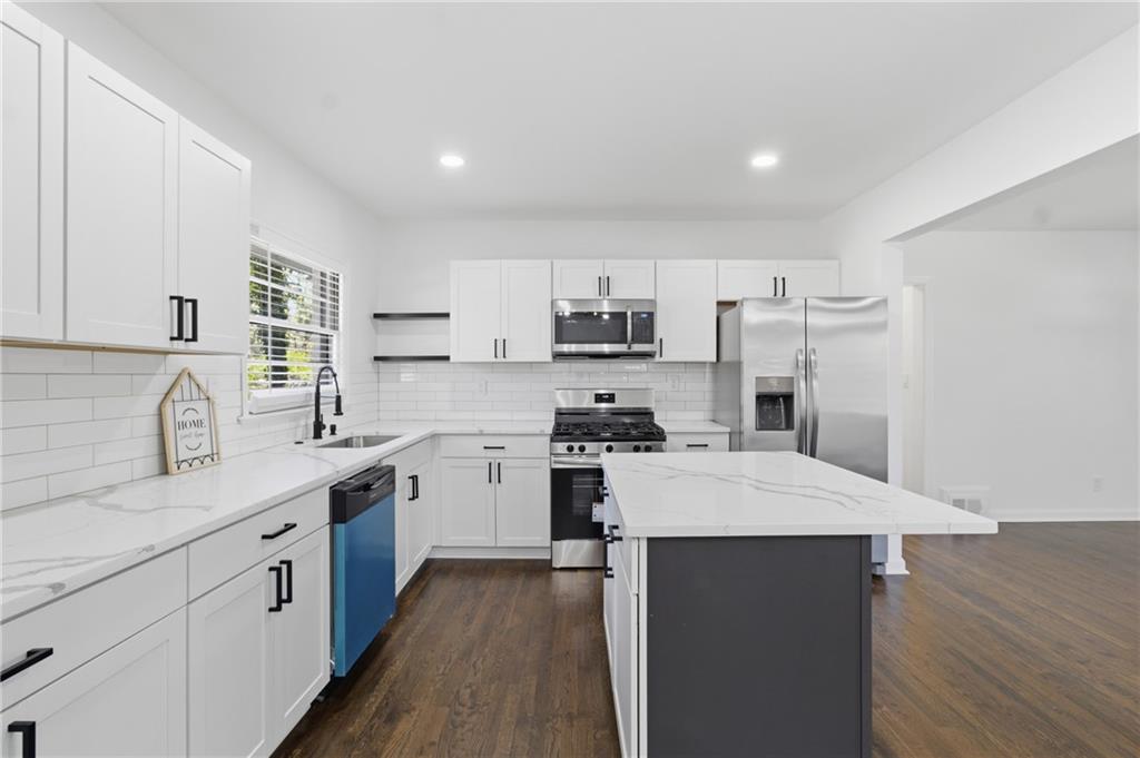 1410 Willis Mill Road Southwest Atlanta, GA 30311 - Photo 7 of 33 a large kitchen with cabinets stainless steel appliances a sink and a counter top space