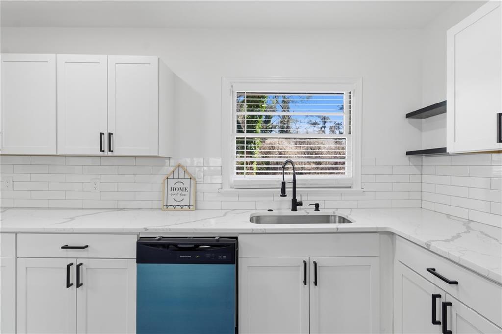 1410 Willis Mill Road Southwest Atlanta, GA 30311 - Photo 8 of 33 a kitchen with stainless steel appliances granite countertop white cabinets sink and window