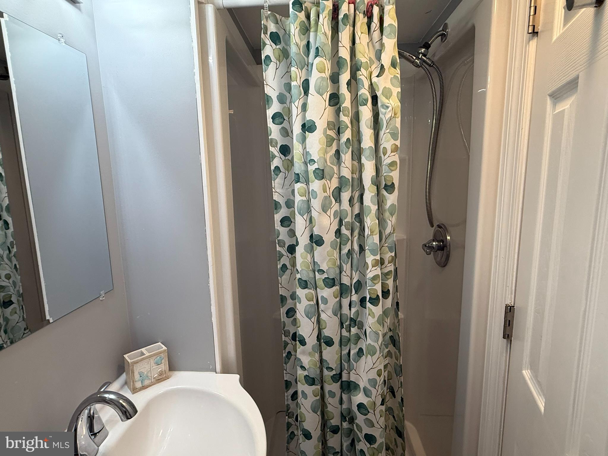 117 Clamshell Road Ocean City, MD 21842 - Photo 8 of 14 a bathroom with a shower curtain and a sink