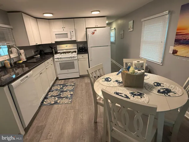 a kitchen with stainless steel appliances kitchen island granite countertop a sink a stove a refrigerator and island