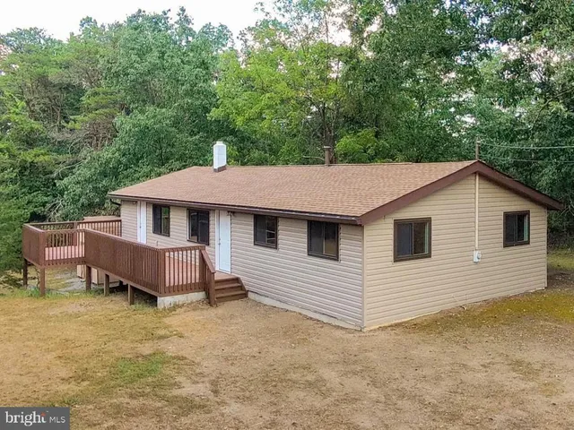 a large kitchen with a center island wooden floor stainless steel appliances and a window