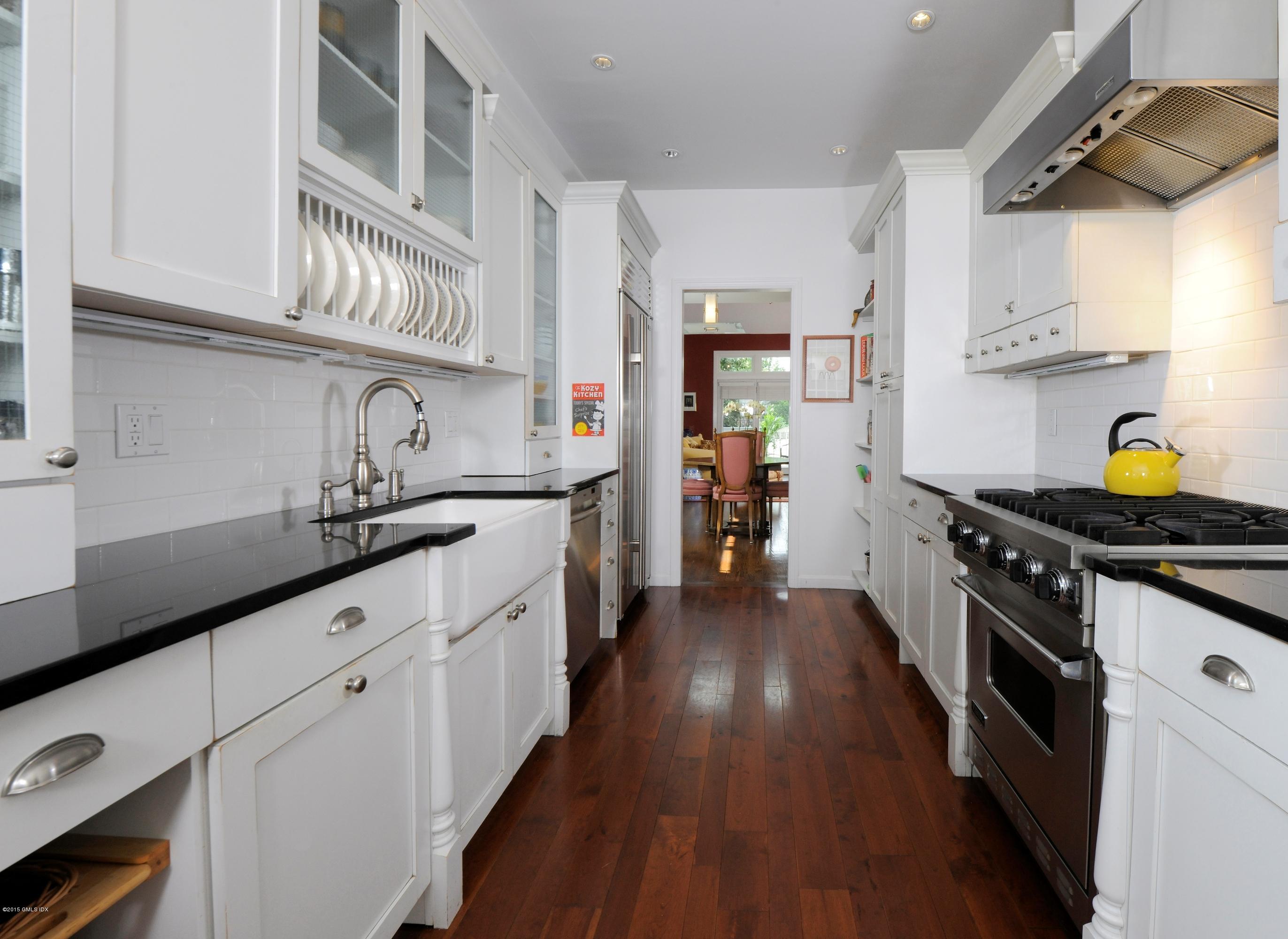 186 Field Point Road, Unit 4A Greenwich, CT 06830 - Photo 5 of 23 a kitchen with stainless steel appliances a sink and wooden floors