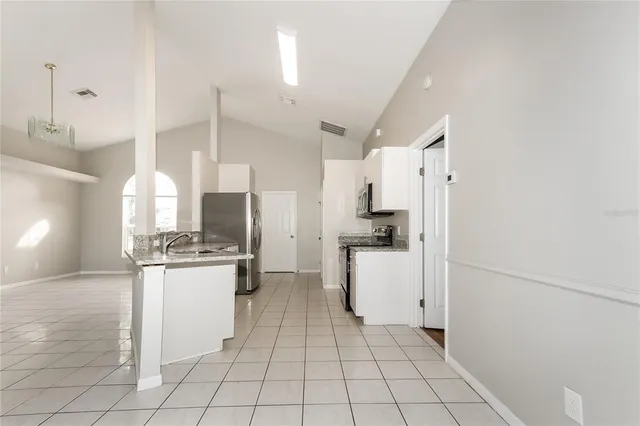 a kitchen with a refrigerator a stove top oven and cabinets