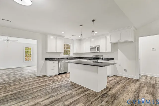 a kitchen with granite countertop a sink and a stove top oven