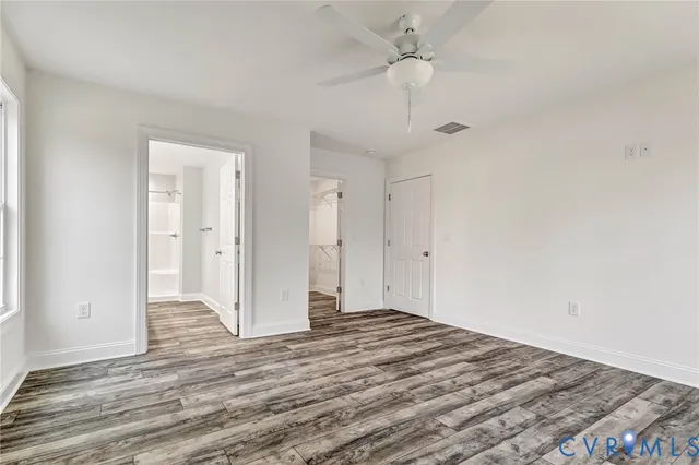 a view of a room with wooden floor and a ceiling fan
