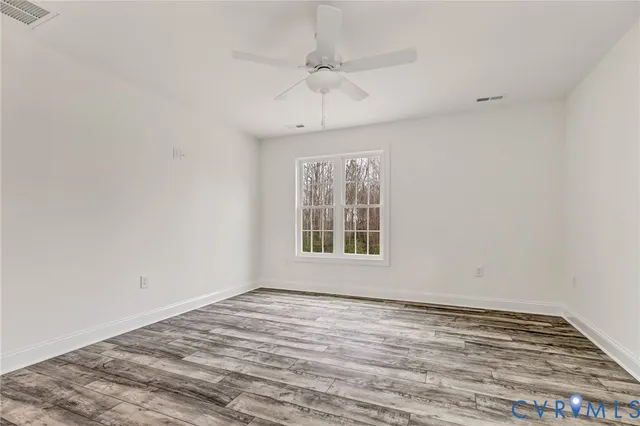 wooden floor in an empty room with a window