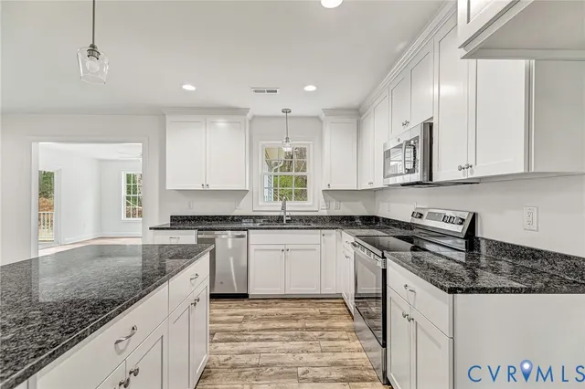 a kitchen with granite countertop cabinets stainless steel appliances and a counter space