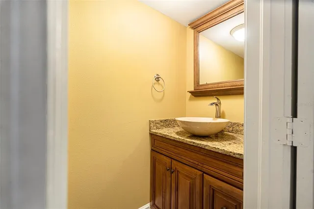 a kitchen with granite countertop a stove a sink and a refrigerator with wooden floors