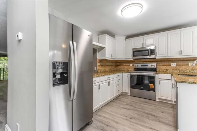 an empty room with wooden floor a ceiling fan and fireplace