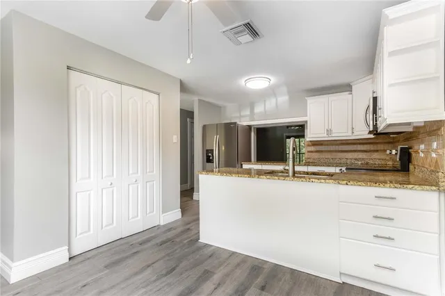 a view of a hallway with wooden floor and entryway