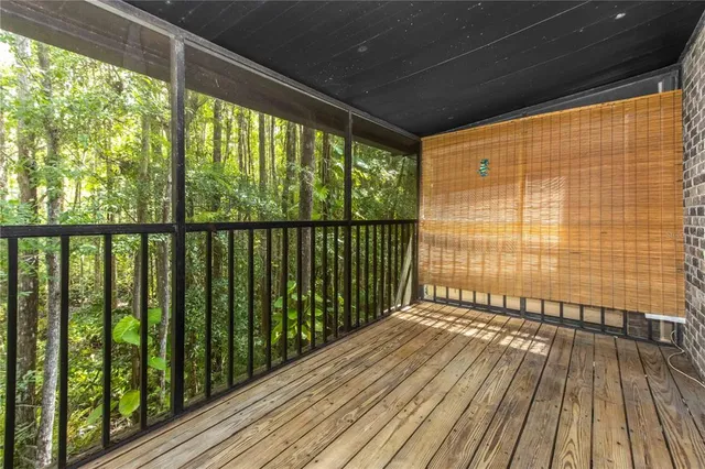 an empty room with wooden floor ceiling fan and windows