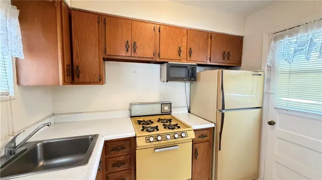 a kitchen with stainless steel appliances white cabinets and a refrigerator