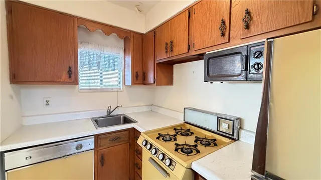 a kitchen with stainless steel appliances granite countertop a stove a sink and a microwave