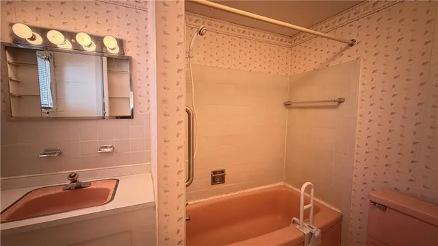 a bathroom with a tub a sink and mirror