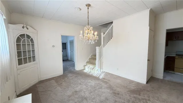 a view of a big room with chandelier and entryway